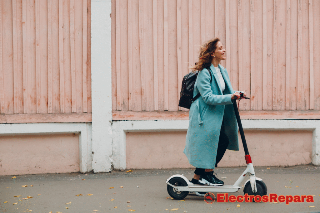 La imagen muestra a una joven sonriente disfrutando de un paseo en un patinete eléctrico. Su expresión facial sugiere una experiencia agradable y cómoda, lo cual se relaciona directamente con el concepto de "comodidad en carretera". Aunque la suspensión del patinete no es el elemento visual principal, la comodidad del conductor durante el viaje indica que el diseño del patinete contribuye a una experiencia de conducción suave y placentera.