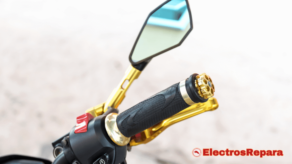 Un primer plano del puño de gas moto eléctrica con detalles en dorado, mostrando su textura y diseño ergonómico. Se aprecian también el espejo retrovisor y la maneta de freno, resaltando la interfaz del piloto con la motocicleta eléctrica. La imagen captura la calidad y el detalle de los componentes del manillar, esenciales para el control y la experiencia de conducción.