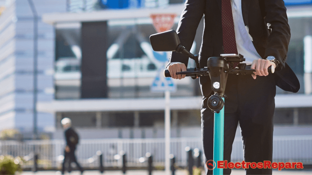 Un hombre de negocios, elegantemente vestido con un traje oscuro, camisa blanca y corbata con un diseño, está conduciendo un Manillar de Patinete Eléctrico de un vibrante color azul. Se puede observar que el hombre lleva un reloj en su muñeca izquierda y sujeta firmemente el manillar con ambas manos, mostrando ligeramente los nudillos. El patinete parece ser un modelo moderno y está equipado con un espejo retrovisor en el lado izquierdo del manillar. El fondo es un entorno urbano borroso con edificios y elementos de la calle, sugiriendo que se encuentra en movimiento.