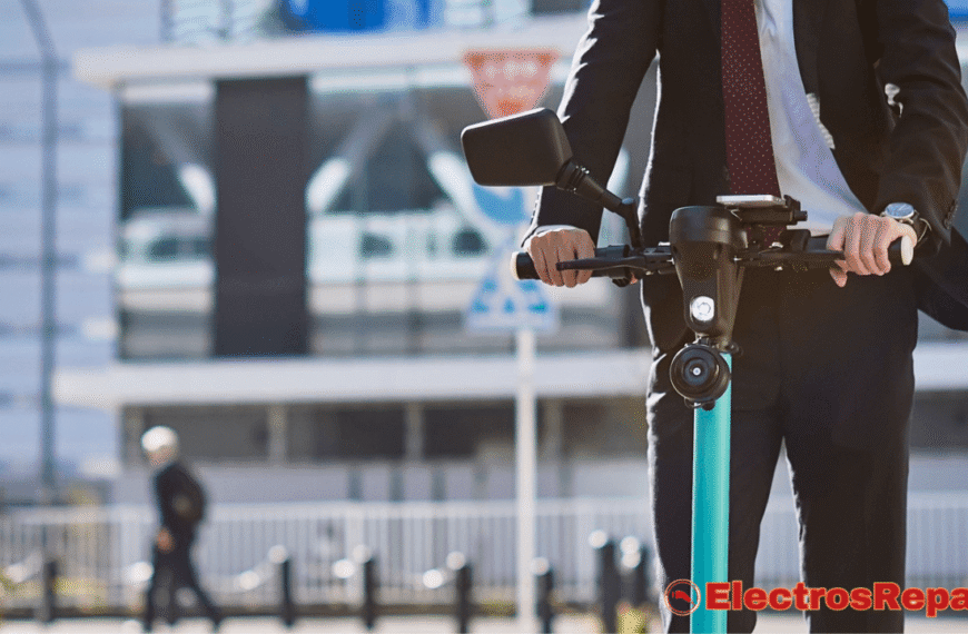 Un hombre de negocios, elegantemente vestido con un traje oscuro, camisa blanca y corbata con un diseño, está conduciendo un Manillar de Patinete Eléctrico de un vibrante color azul. Se puede observar que el hombre lleva un reloj en su muñeca izquierda y sujeta firmemente el manillar con ambas manos, mostrando ligeramente los nudillos. El patinete parece ser un modelo moderno y está equipado con un espejo retrovisor en el lado izquierdo del manillar. El fondo es un entorno urbano borroso con edificios y elementos de la calle, sugiriendo que se encuentra en movimiento.