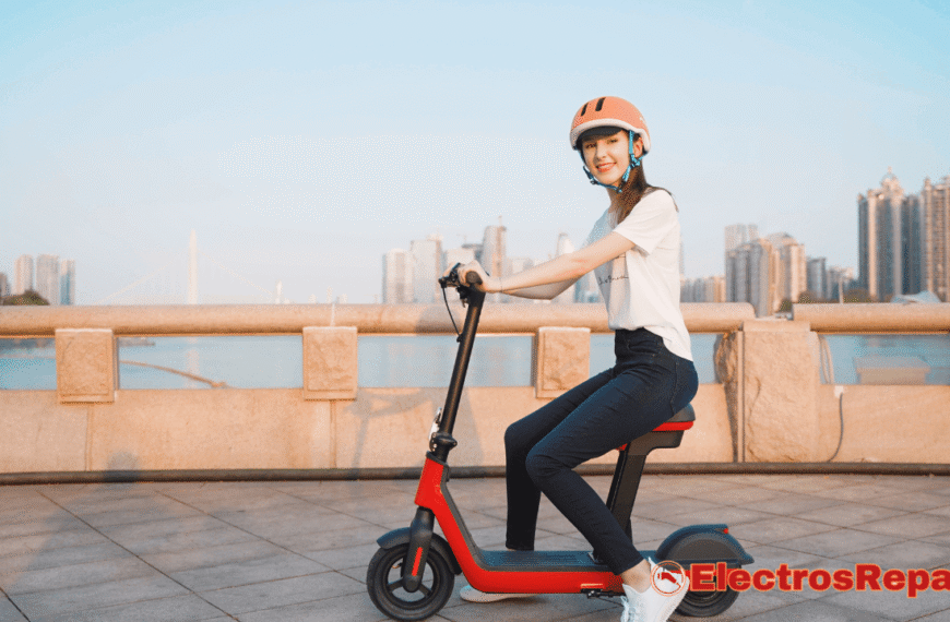 La imagen muestra a una joven con casco de seguridad que está sentada sobre un patinete eléctrico de color rojo y negro. El patinete tiene un asiento, lo que le da un aspecto similar a una calavera de bicicleta. La mujer está sonriendo y parece estar disfrutando de un paseo al aire libre, con un paisaje urbano de fondo. La foto sugiere la libertad y la practicidad del transporte personal eléctrico, resaltando la importancia de un buen mantenimiento del motor de patinete eléctrico para garantizar un rendimiento óptimo y una experiencia de uso segura.